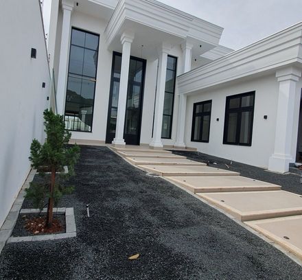 fachada de casa com pedrisco escuro e passarela de concreto, antes da instalação