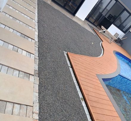faixa lateral de pedrisco cinza ao lado do deck da piscina, antes da instalação